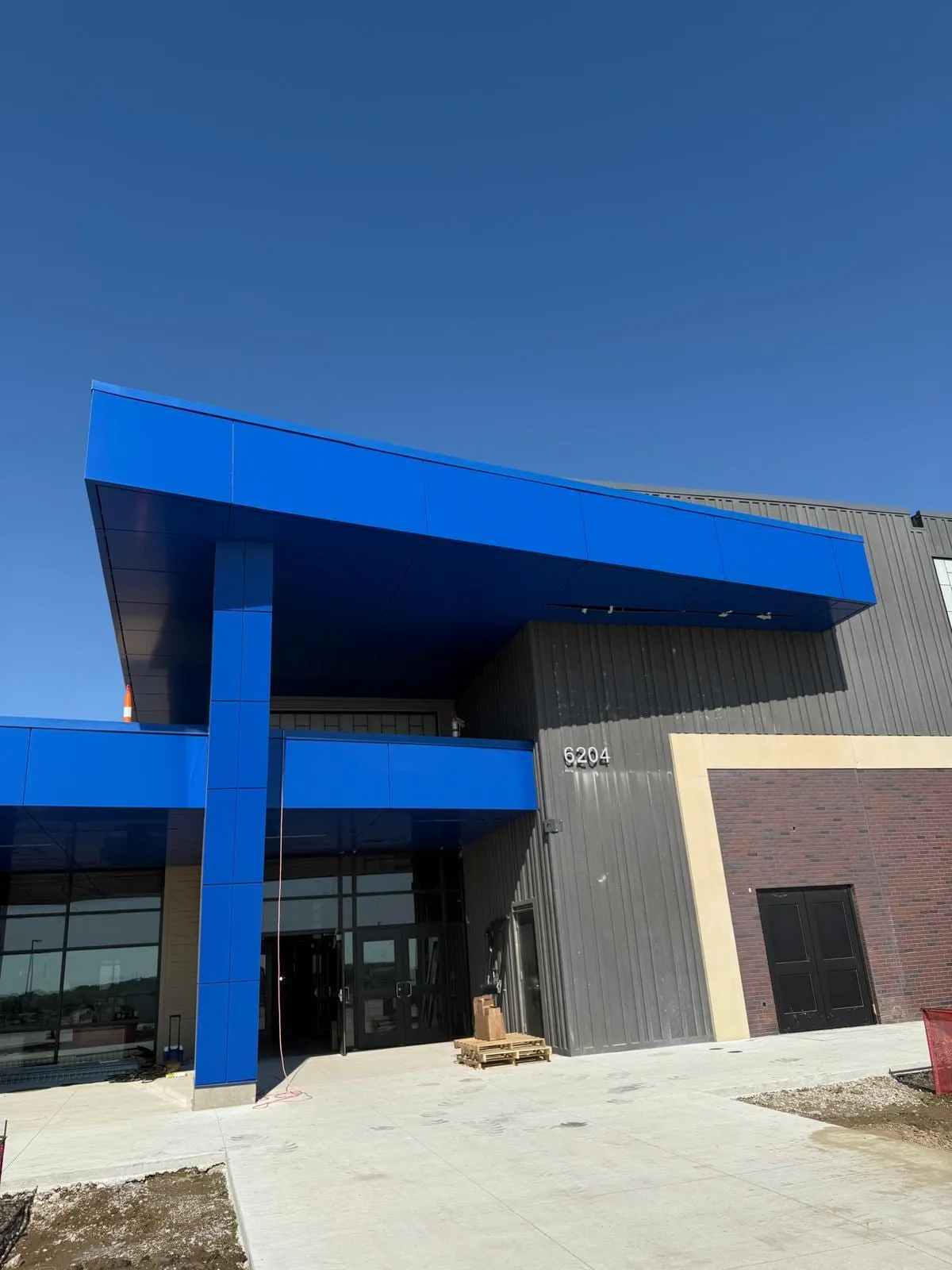 Stone Pointe Elementary — ACM azul en ambos accesos — columnas, fascias, plafones y transiciones — más panel de muro Morin en los muros de azotea. (3/12)