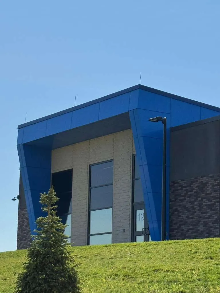 Iron Bluff Elementary — ACM azul en ambos accesos — columnas, fascias, plafones y transiciones — más panel de muro Morin en los muros de azotea. (5/8)